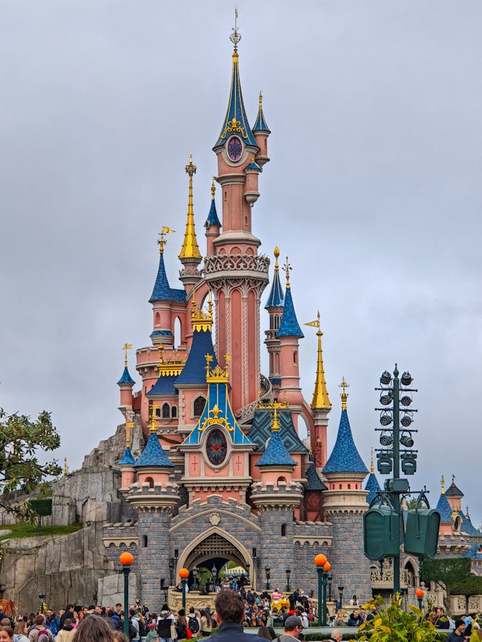 about-01 Iconic fairytale castle with colorful towers at a popular theme park, attracting visitors worldwide.